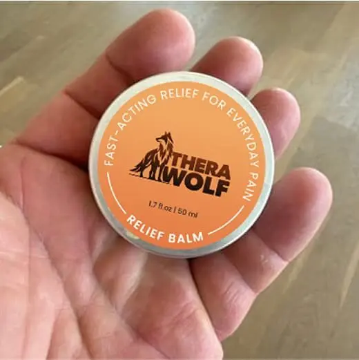 TheraWolf Relief Balm tin held in one hand